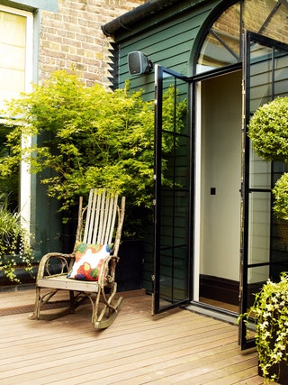 Image may contain Furniture Chair Vase Plant Pottery Potted Plant Jar Porch Door Patio and Outdoors