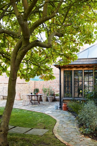 Image may contain Plant Outdoors Tree Yard Nature Vase Pottery Potted Plant Jar Garden Patio Furniture and Chair