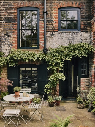 Image may contain Plant Desk Furniture Table Chair Cup Architecture Building Housing Door House and Window